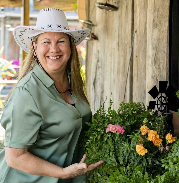 woman in white cowboy hat with flourishing plants